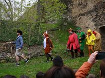 Szenische Aufführung auf einer Wiese auf Burg Ranis mit mehreren verkleideten Darstellern, darunter ein Igel, Eichhörnchen, Fuchs, Raupe, Küken und Huhn.