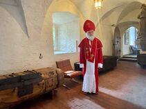 Darsteller als Bischof vor den historischen Einbaumtruhen im Museum Burg Ranis bei „Das Museum erwacht“